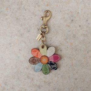 Coach multi colored daisy cloth, leather & brass hang tag